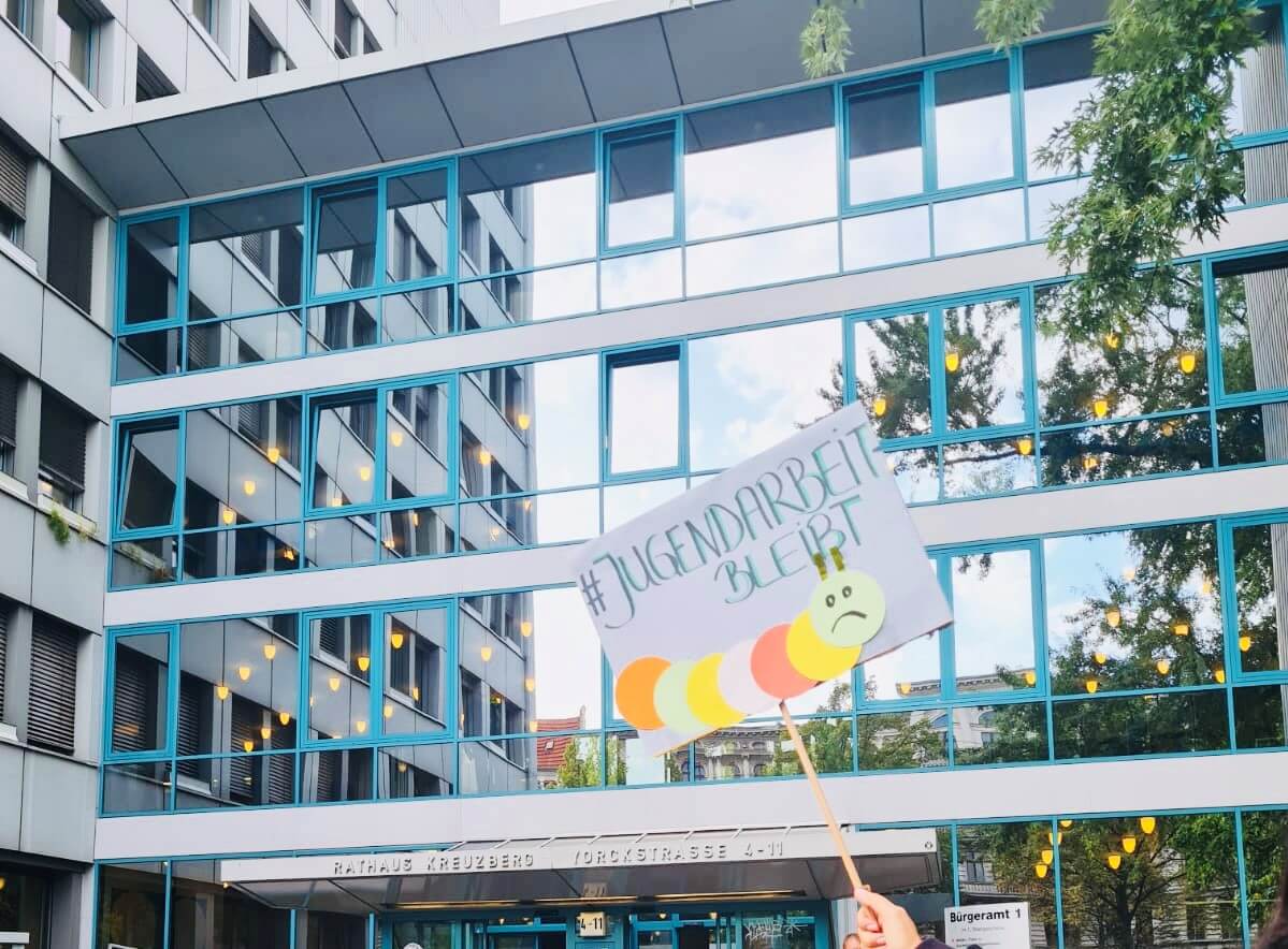 Protest Schild vor Gebäude: Klimagerechtigkeit jetzt!