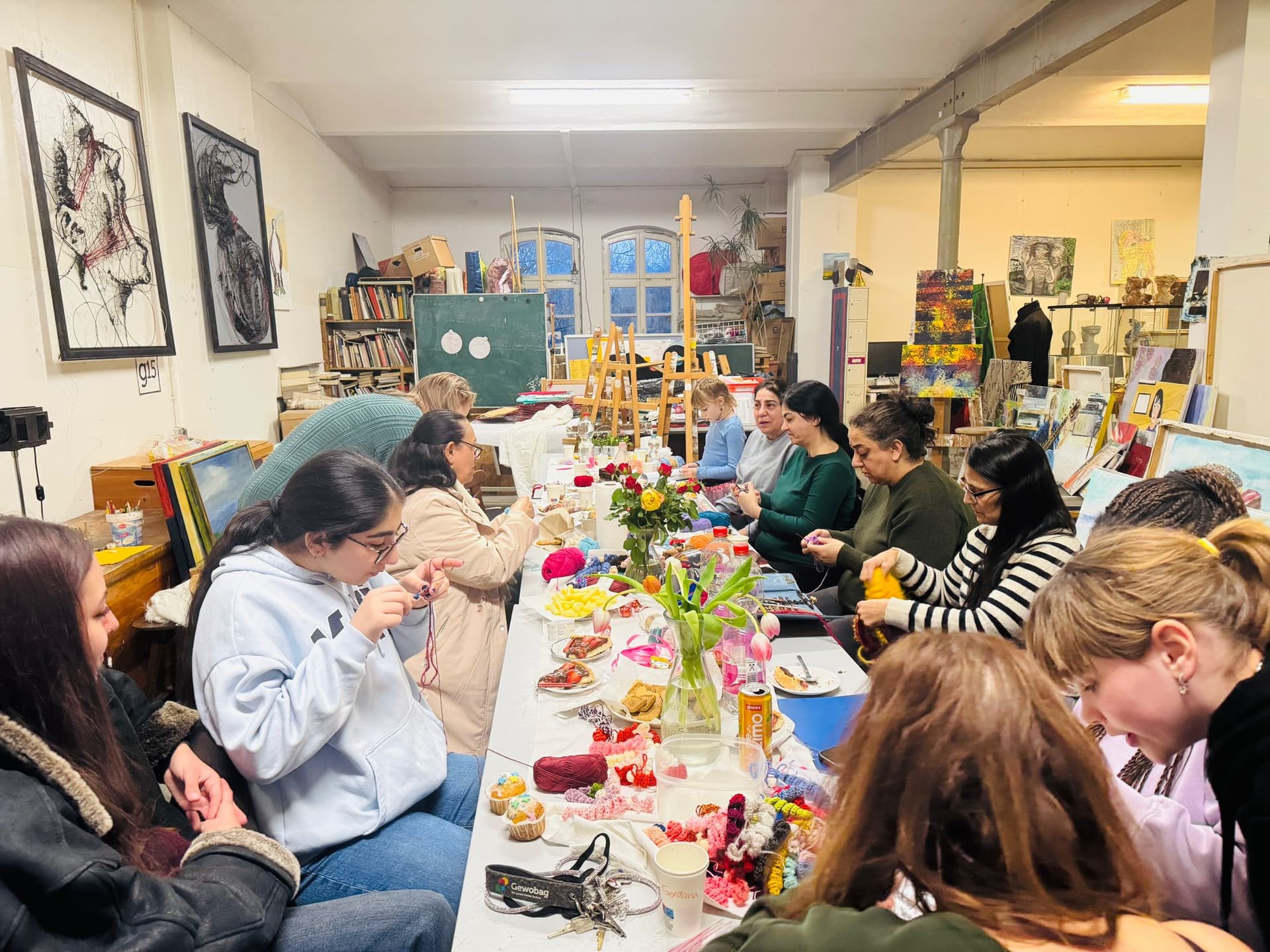 Mehrer Personen sitzen an einem Tisch und Häkeln gemeinsam.